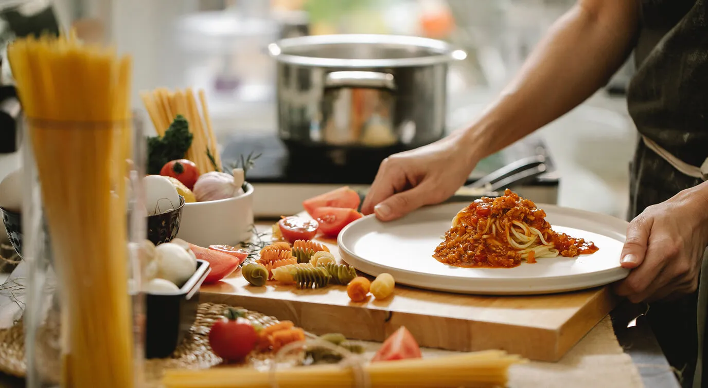 Cooking spaghetti with ground meat and tomatoes in the kitchen